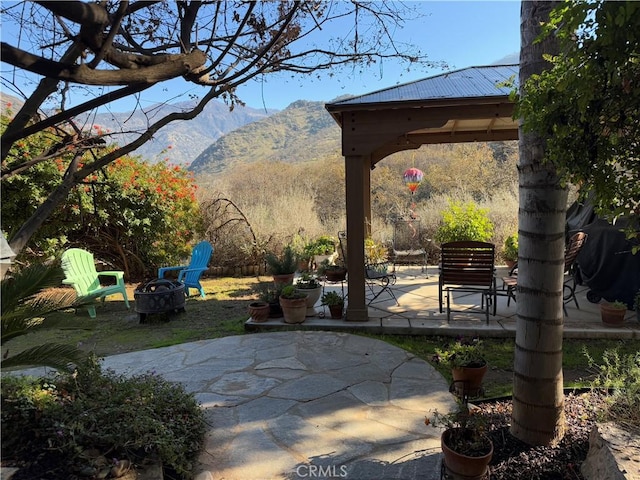 view of patio / terrace featuring a gazebo, a mountain view, and an outdoor fire pit