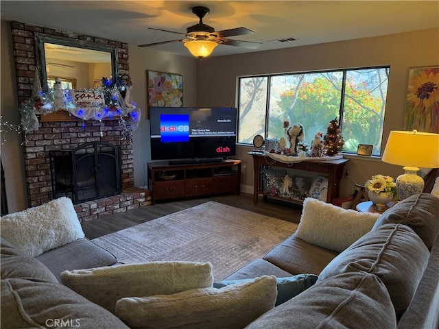 living room with ceiling fan, a brick fireplace, and hardwood / wood-style flooring