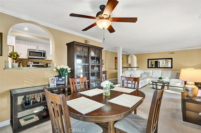 27704 Campanet Unit 31, Mission Viejo, CA 92692 - dining area with crown molding, arched walkways, ceiling fan, light colored carpet, and baseboards