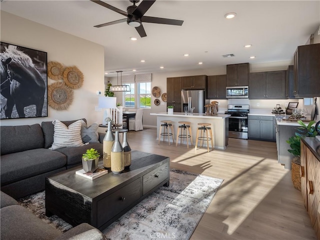 living room featuring ceiling fan and light hardwood / wood-style flooring