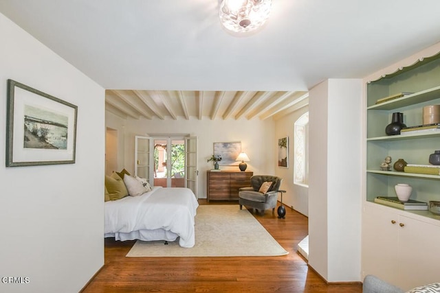 bedroom with hardwood / wood-style floors and beamed ceiling