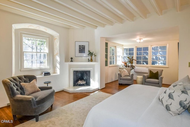 bedroom with hardwood / wood-style floors and beam ceiling