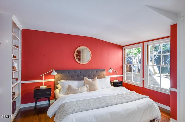 bedroom with multiple windows, wood-type flooring, and vaulted ceiling