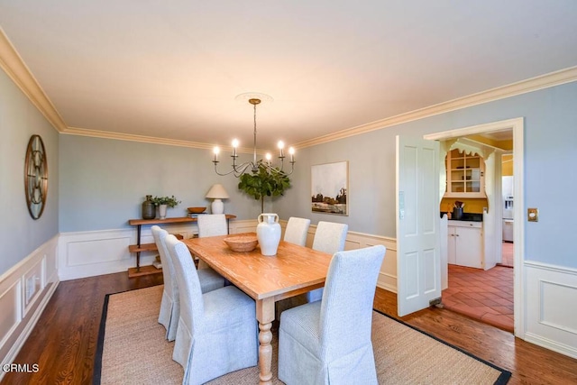 dining space featuring ornamental molding, dark hardwood / wood-style floors, and a chandelier