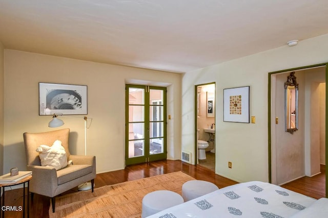 bedroom featuring ensuite bathroom, hardwood / wood-style floors, and french doors