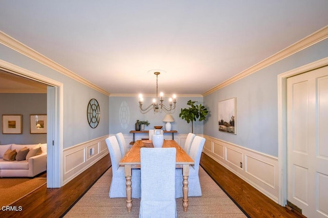 dining area featuring crown molding, dark hardwood / wood-style floors, and an inviting chandelier