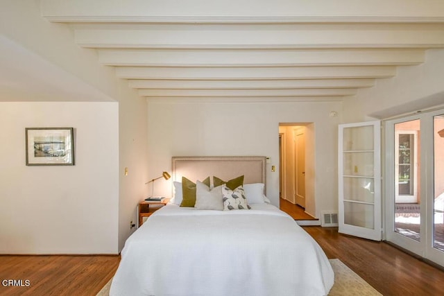 bedroom featuring beam ceiling and dark wood-type flooring