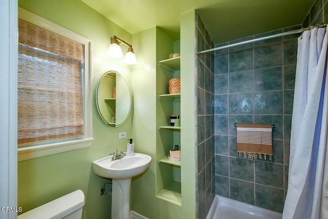 bathroom featuring a shower with curtain, toilet, and sink