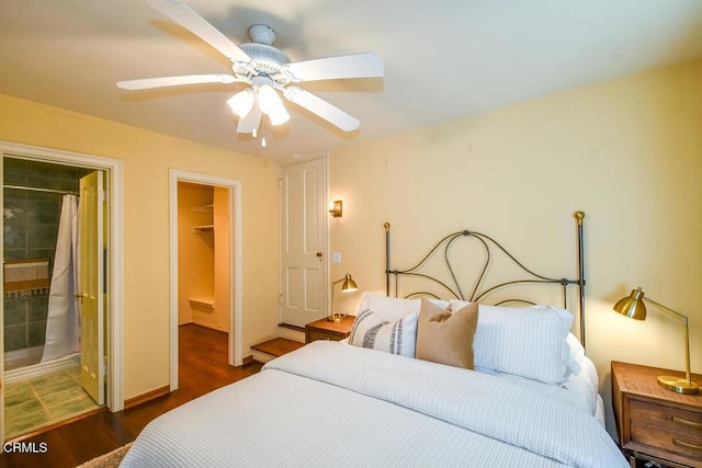 bedroom featuring ensuite bathroom, a spacious closet, dark hardwood / wood-style floors, a closet, and ceiling fan