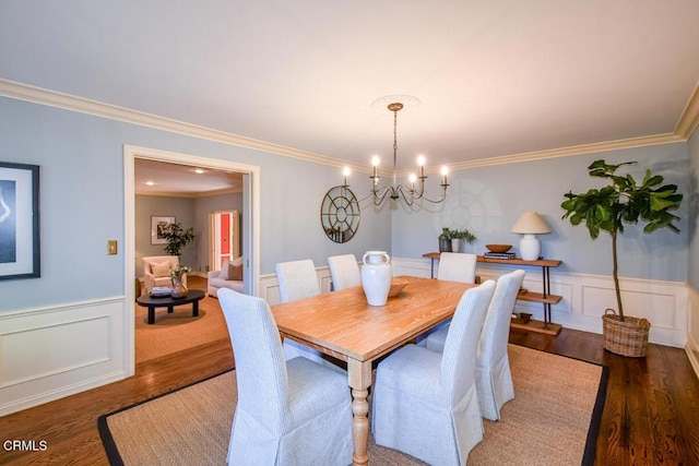 dining area featuring crown molding, dark wood-type flooring, and a chandelier