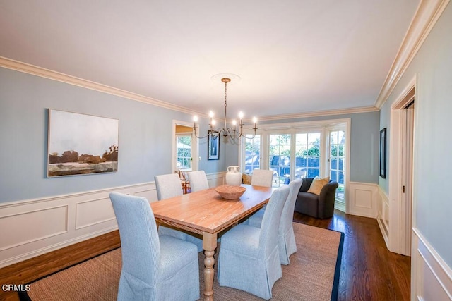 dining space featuring an inviting chandelier, ornamental molding, and dark hardwood / wood-style flooring