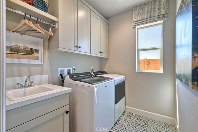 laundry area with washer and dryer, cabinets, and sink