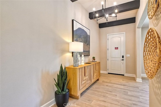 entrance foyer featuring light hardwood / wood-style flooring and a chandelier