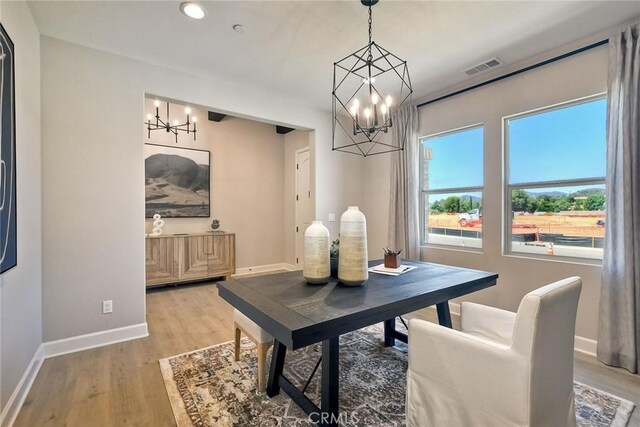 dining space featuring hardwood / wood-style floors and a chandelier