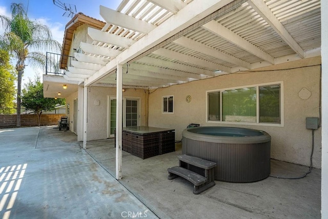 view of patio with a hot tub and a pergola