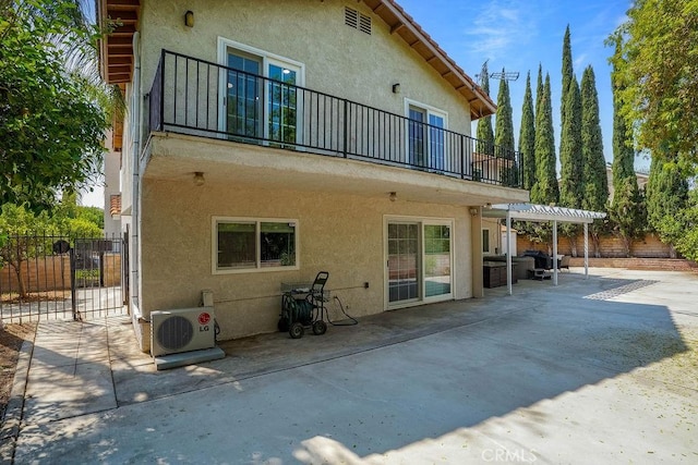 rear view of house with a pergola, a patio, a balcony, and ac unit