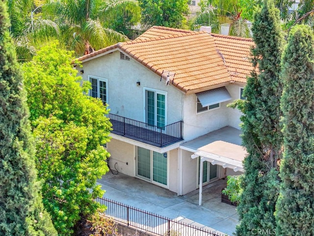 rear view of house featuring a patio area and a balcony