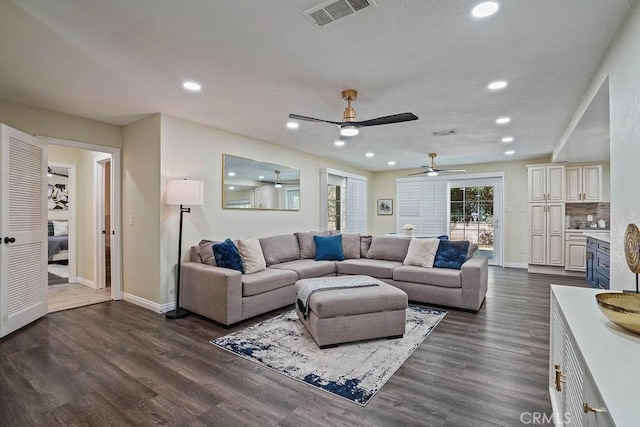 living room featuring ceiling fan and dark wood-type flooring