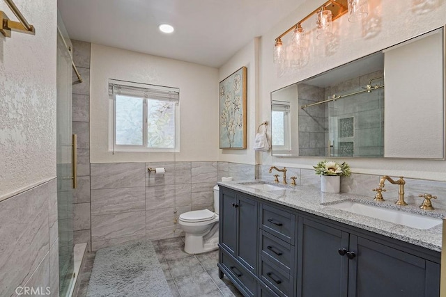 bathroom featuring toilet, a tile shower, tile walls, and vanity