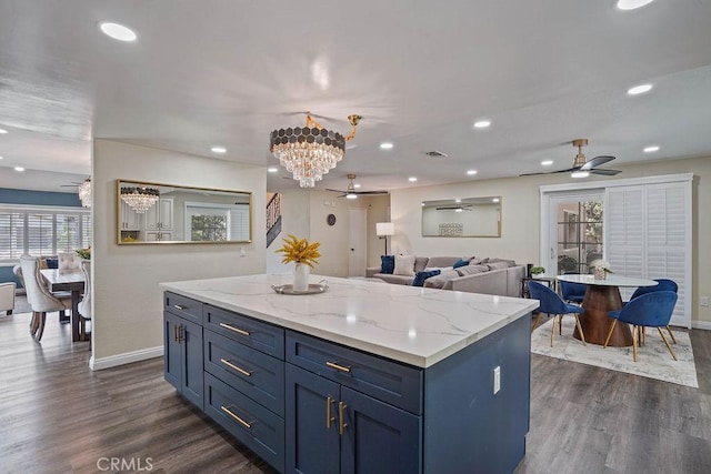 kitchen with dark hardwood / wood-style floors, pendant lighting, blue cabinetry, and a kitchen island