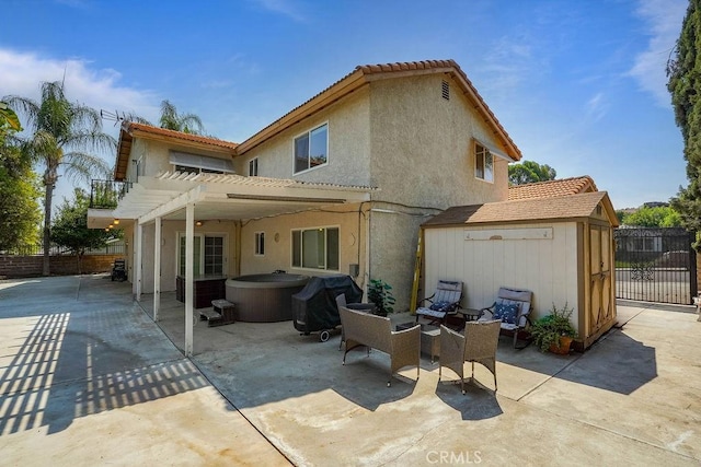 back of house featuring a storage shed, a patio area, a hot tub, an outdoor living space, and a pergola