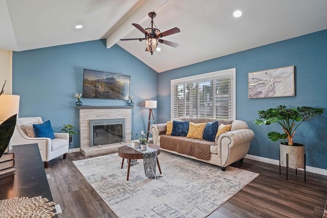 living room with dark hardwood / wood-style floors, ceiling fan, a fireplace, and vaulted ceiling with beams