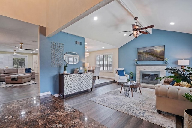 living room featuring ceiling fan, dark hardwood / wood-style floors, and vaulted ceiling with beams