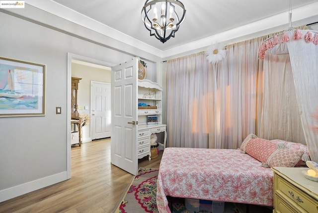 bedroom featuring light hardwood / wood-style flooring and a notable chandelier