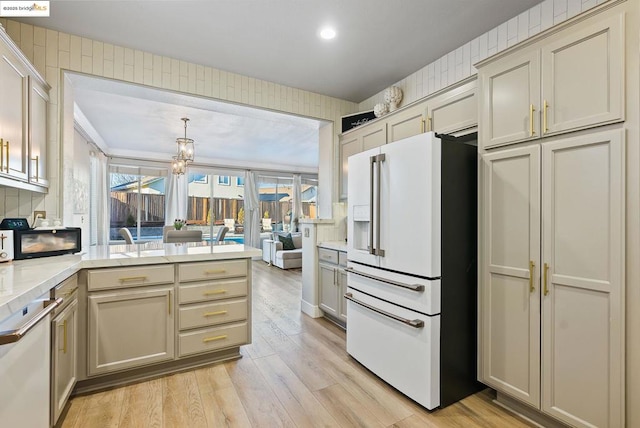 kitchen with stainless steel dishwasher, decorative backsplash, hanging light fixtures, light wood-type flooring, and white fridge with ice dispenser