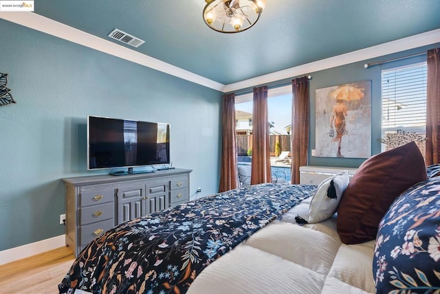 bedroom with crown molding and light hardwood / wood-style floors