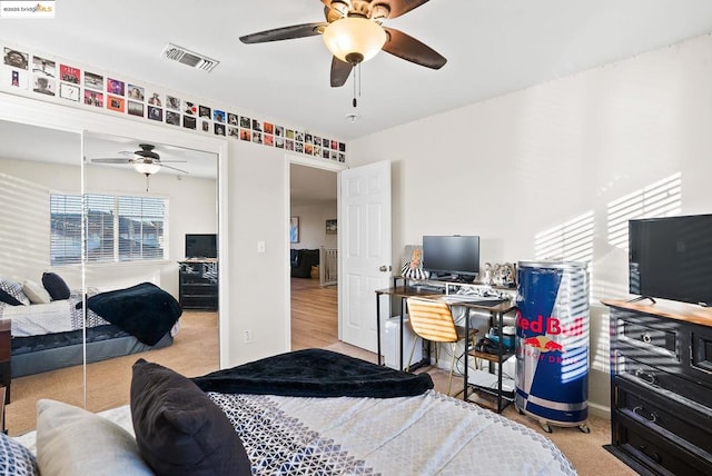 carpeted bedroom featuring ceiling fan and a closet