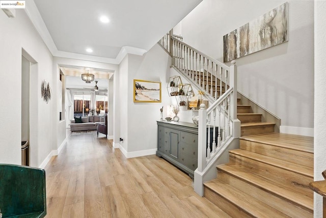 stairway with hardwood / wood-style flooring and an inviting chandelier