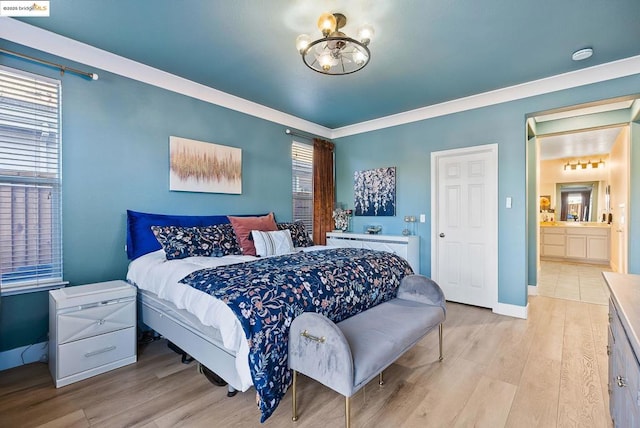 bedroom with connected bathroom, an inviting chandelier, ornamental molding, and light hardwood / wood-style flooring