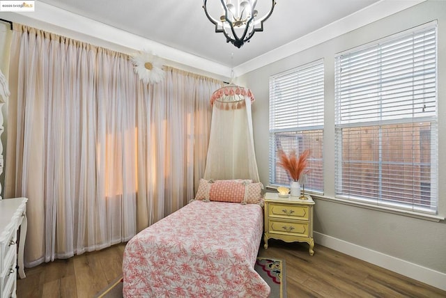 bedroom featuring dark hardwood / wood-style flooring, crown molding, and a chandelier