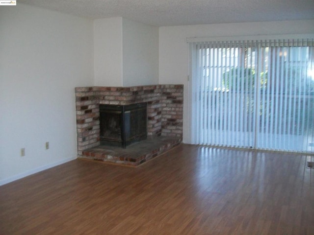 unfurnished living room featuring a textured ceiling and wood-type flooring