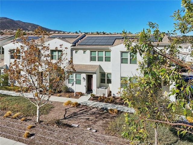 multi unit property with a mountain view and solar panels