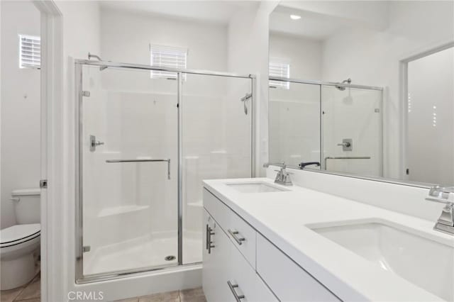 bathroom with a shower with door, vanity, a healthy amount of sunlight, and toilet