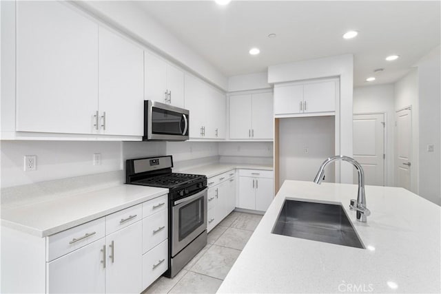 kitchen featuring appliances with stainless steel finishes, sink, and white cabinets