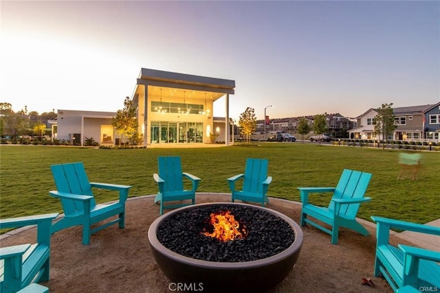 patio terrace at dusk with a lawn and an outdoor fire pit