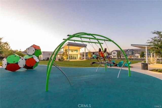 playground at dusk featuring a lawn