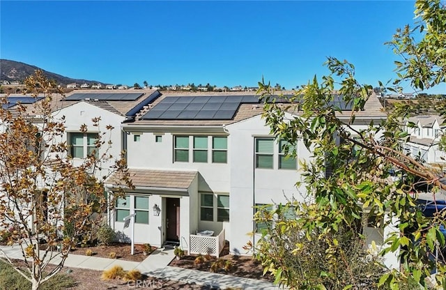 view of front of home featuring a mountain view and solar panels