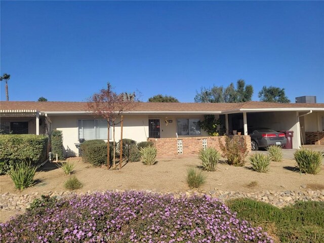 ranch-style house with central AC and a carport