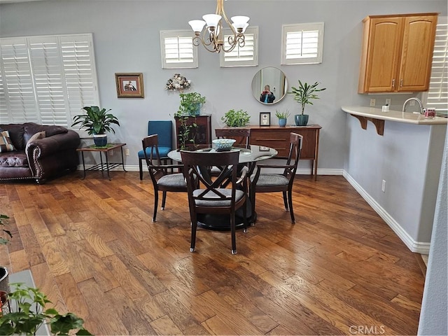 dining room with dark wood-type flooring and a chandelier