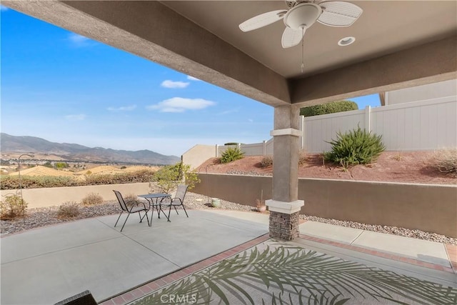 view of patio / terrace featuring a mountain view and ceiling fan