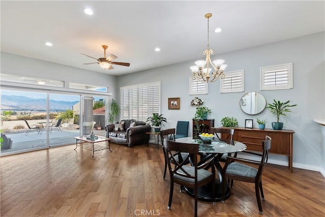 dining area with ceiling fan with notable chandelier and hardwood / wood-style floors