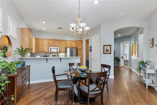 dining room with dark hardwood / wood-style flooring and a notable chandelier