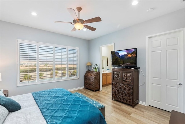 bedroom featuring ceiling fan, ensuite bath, and light hardwood / wood-style floors