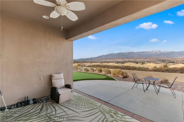 view of patio with a mountain view and ceiling fan