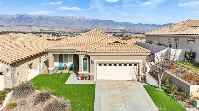 mediterranean / spanish house with a patio, a garage, a mountain view, and a front lawn