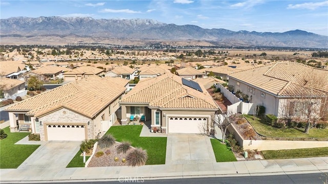 view of front facade with a mountain view, a garage, and a front lawn